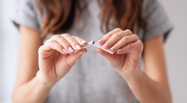 Woman breaking cigarette in two