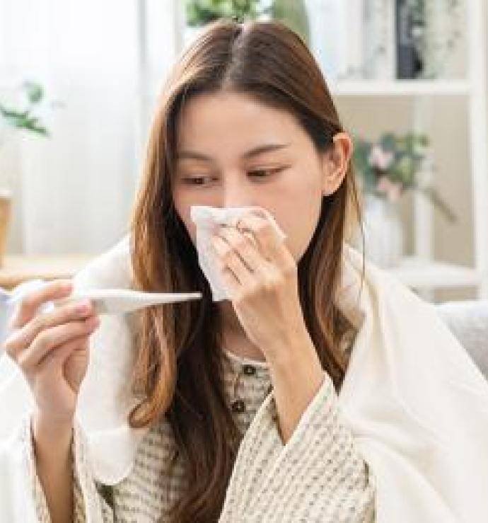Zieke vrouw gebruikt thermometer
