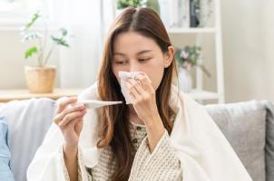 Zieke vrouw gebruikt thermometer