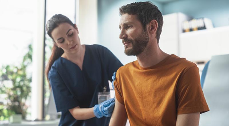 Doctor giving man a vaccination shot