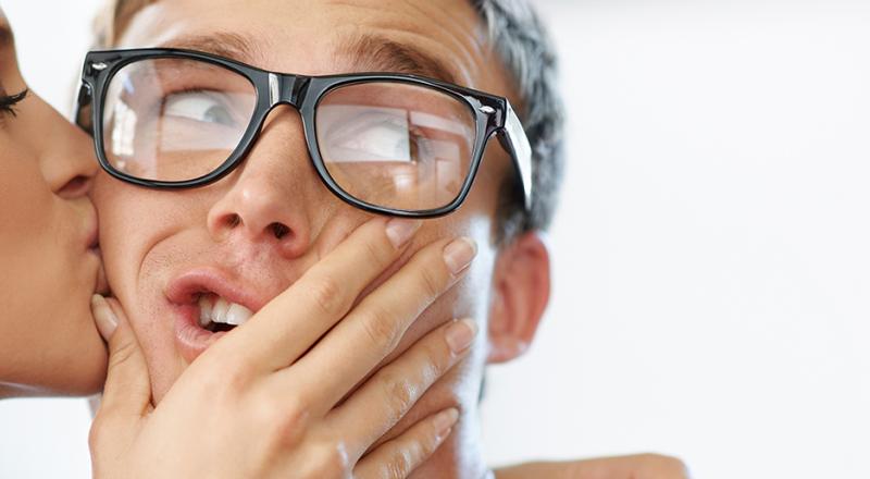 woman kissing man with glasses