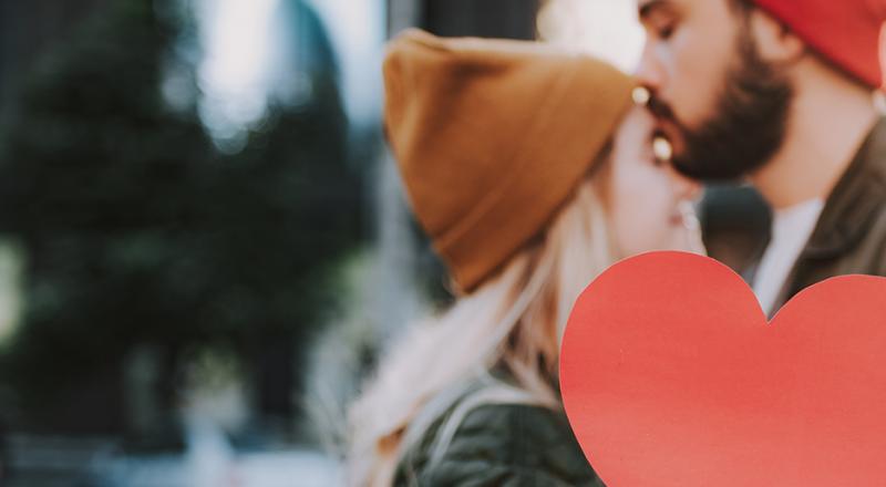 yound couple holding paper heart