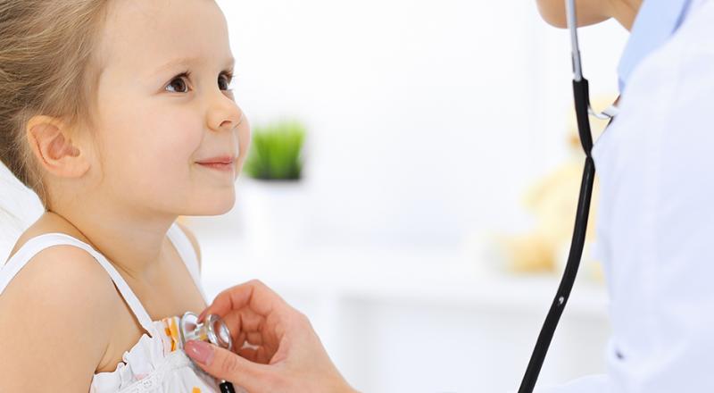 doctor listening to little girl's heart